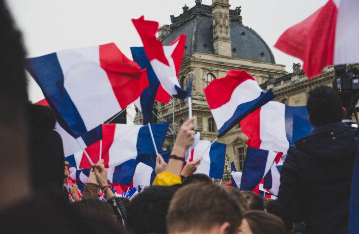 People outside the Louvre waving french flags